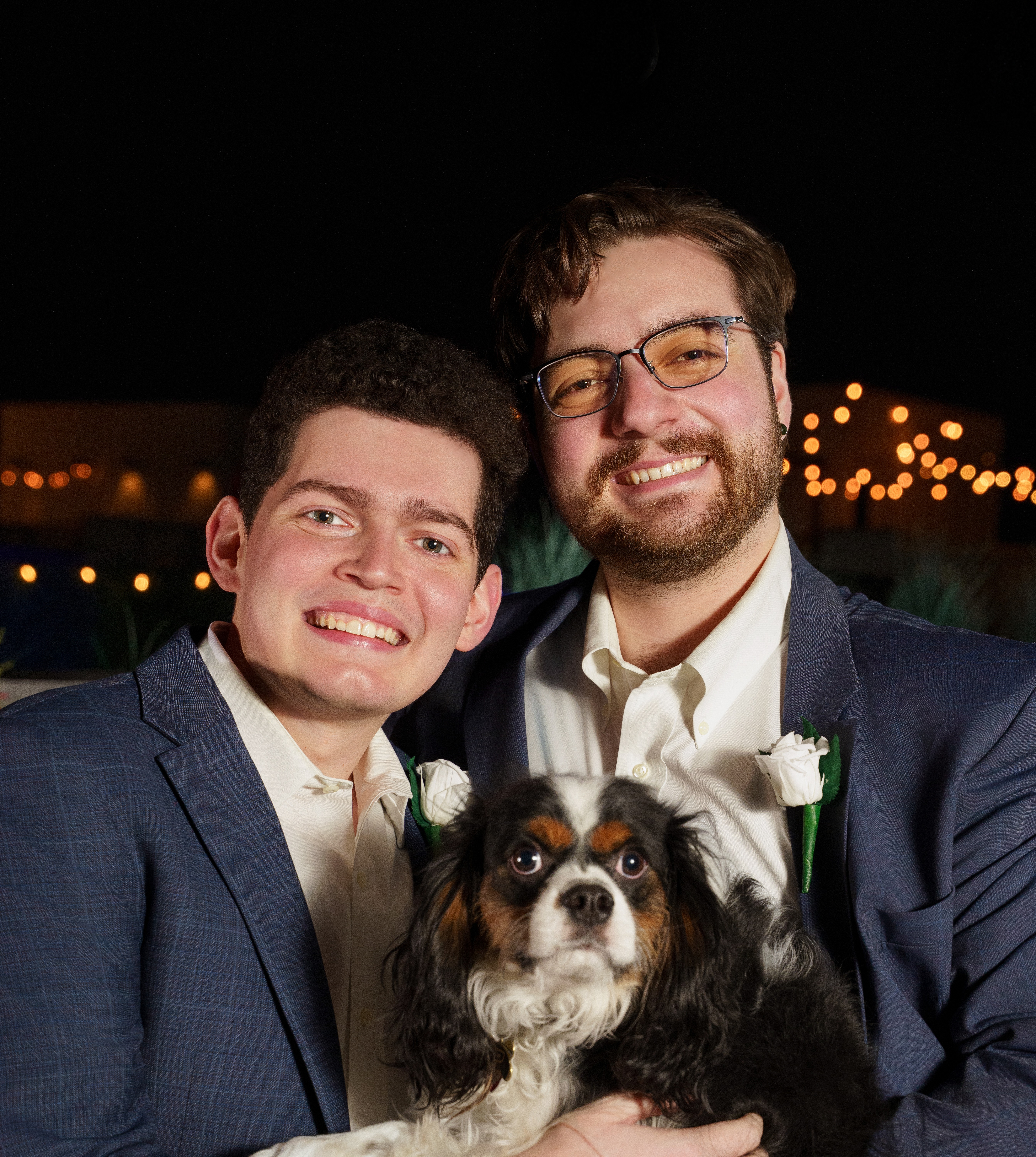 Kaleb and James with their dog in formalwear.